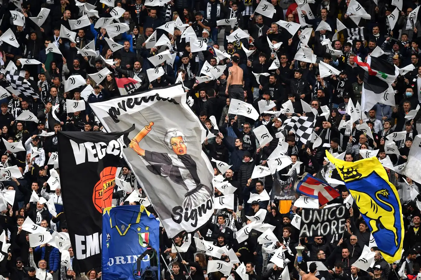Tifosi della Juventus allo stadio con bandiere bianconere